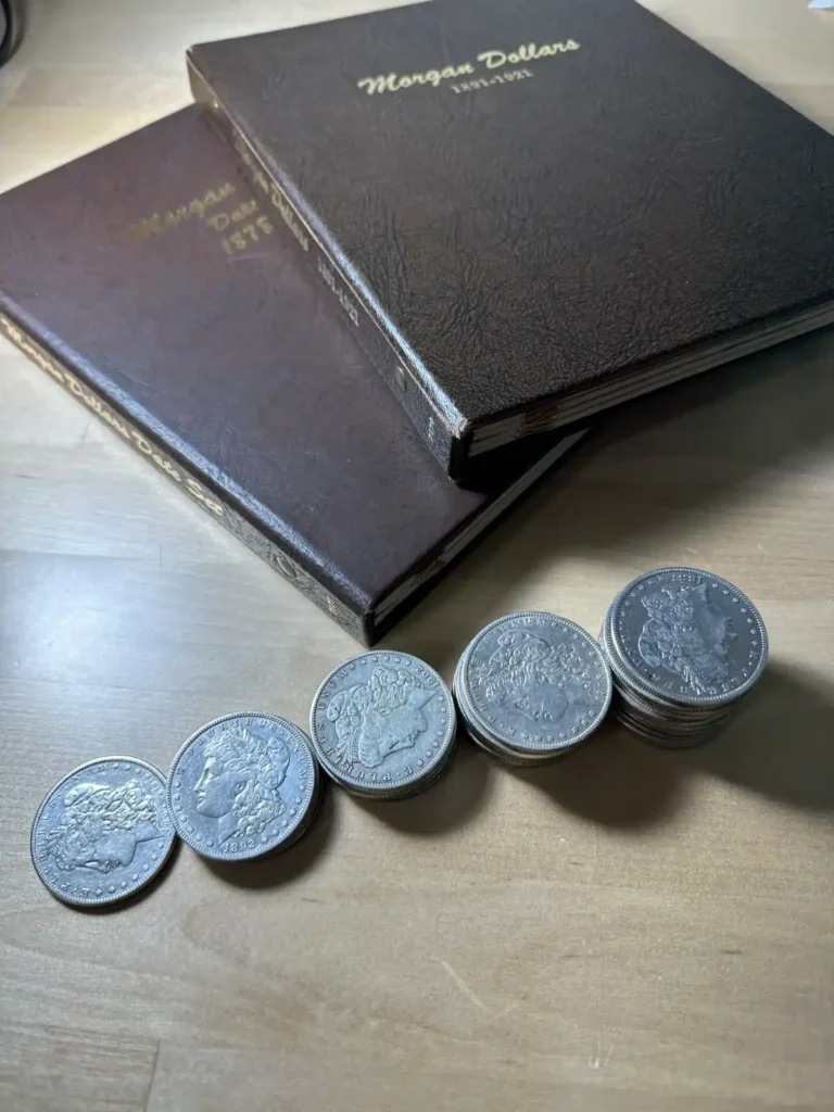 The Ultimate Guide to Selling Your Coin Collection - Morgan Dollar coin collections in a table with coin book - learn how to sell a coin collection