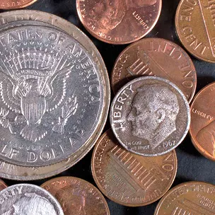Various coins including a half dollar and several pennies, with a focus on a 1967 dime