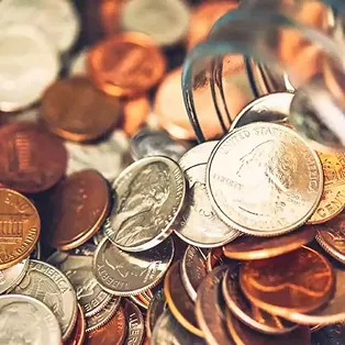 A close-up of various U.S. coins, including pennies, nickels, dimes, and quarters