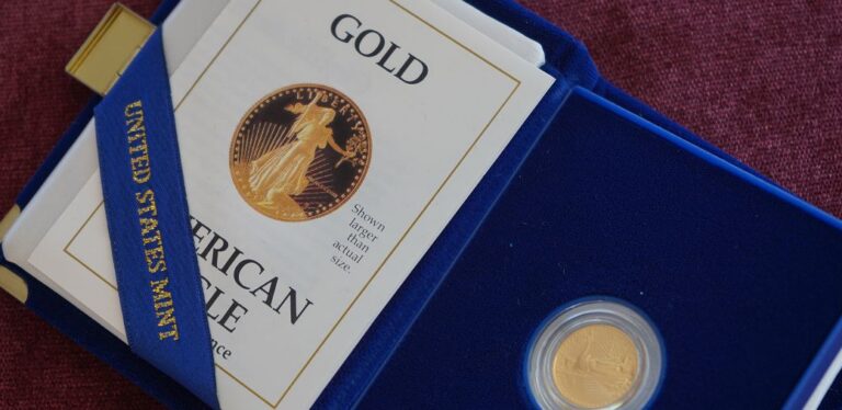 Gold American Eagle coin in a blue display case with a booklet titled "Gold"