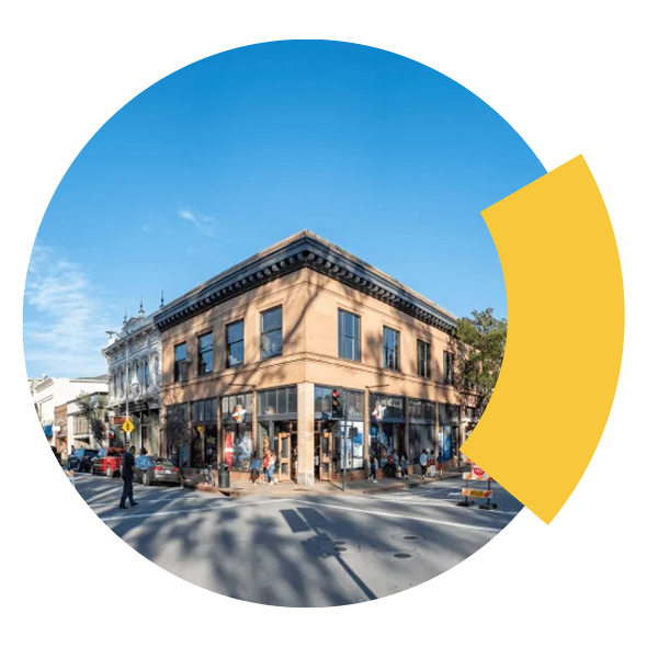 Corner brick building with storefronts on a city street